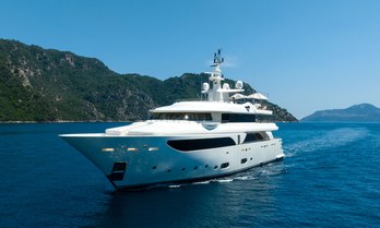 Charter yacht LADY I underway with elevated terrain aft