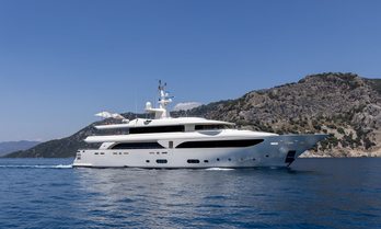 Charter yacht LADY I underway with cliffs in background