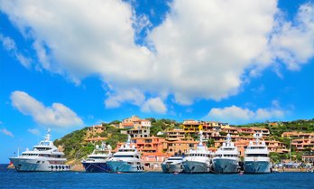 A line of charter yachts at anchor in a bay 