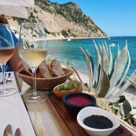 Alfresco dining layout with glasses of wine overlooking the sea