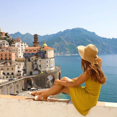 A female charter guest in a yellow dress overlooking the Amalfi Coast