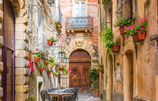 Cafe tables and chairs outside in old cozy street in the Positano town, Campania, Italy