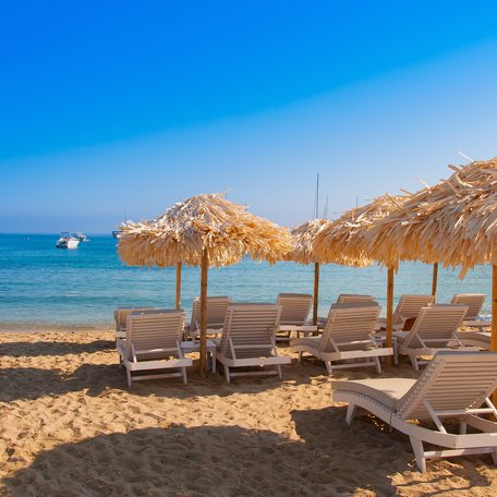 Sandy beach with parasols and sun loungers