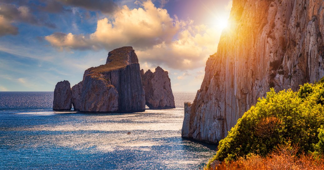 High cliffs of Mediterranean coast, "Pan di Zucchero" stack rock in Masua, west coast of Sardinia, Italy. Concali su terrainu a limestone formation in southern Sardinia, Italy.